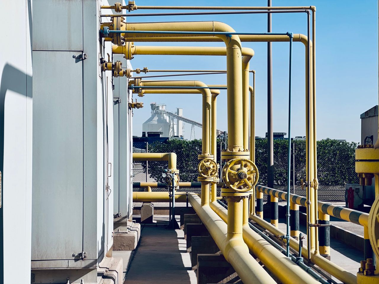 A detailed view of industrial pipelines in a Saudi Arabian factory setting.